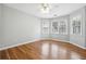 This inviting bedroom has three windows, wood floors, neutral paint, and modern ceiling fan at 385 Sweet Ivy Ln, Lawrenceville, GA 30043