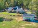 Aerial view showcasing the home with a three-car garage, shed, and manicured lawns and wooded property at 441 Pumpkinvine Rd, Acworth, GA 30101