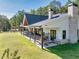 Wide backyard patio with outdoor seating, hanging chairs, and beautifully maintained lawn at 441 Pumpkinvine Rd, Acworth, GA 30101