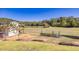 Lush backyard featuring a small storage shed with a lawn and distant pond, perfect for relaxation and outdoor activities at 441 Pumpkinvine Rd, Acworth, GA 30101