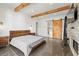 Bedroom showcasing wood beams, a brick fireplace, and a sliding barn door to bathroom at 441 Pumpkinvine Rd, Acworth, GA 30101