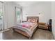 Cozy bedroom with a rustic wood bed frame, patterned bedding, and natural light from the windows at 441 Pumpkinvine Rd, Acworth, GA 30101