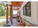 Charming porch with natural wood pillars, brick accents, black framed windows, and artistic wood bench at 441 Pumpkinvine Rd, Acworth, GA 30101