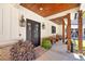Inviting front porch with decorative lanterns, artistic wood seating, and black framed windows at 441 Pumpkinvine Rd, Acworth, GA 30101