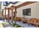 Covered porch featuring wooden beams, brick accents, artistic wooden benches, and black framed windows at 441 Pumpkinvine Rd, Acworth, GA 30101