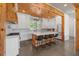 Gourmet kitchen with wood ceiling, white cabinets, large island, stone backsplash, and stainless steel appliances at 441 Pumpkinvine Rd, Acworth, GA 30101