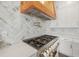 Gourmet kitchen featuring a professional range, stainless steel hood, stone backsplash, and quartz countertops at 441 Pumpkinvine Rd, Acworth, GA 30101