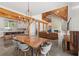 Bright open floor plan featuring exposed beams, a modern kitchen, a dining table, and a stone fireplace at 441 Pumpkinvine Rd, Acworth, GA 30101