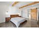 This main bedroom includes hardwood floors, exposed beams, and a sliding barn door to the bath at 441 Pumpkinvine Rd, Acworth, GA 30101