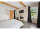 This main bedroom offers hardwood floors, exposed beams, a fireplace, and a sliding barn door to the bath at 441 Pumpkinvine Rd, Acworth, GA 30101