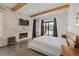 This main bedroom features hardwood floors, exposed beams, a brick fireplace, and modern fixtures at 441 Pumpkinvine Rd, Acworth, GA 30101