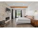 This main bedroom boasts hardwood floors, exposed beams, a brick fireplace, and a sliding glass door at 441 Pumpkinvine Rd, Acworth, GA 30101