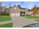 Stately two-story home with a well-manicured front yard, features a brick facade, and a spacious two-car garage at 5619 Sawgrass Cir, Stonecrest, GA 30038