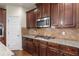 Close-up of kitchen features stainless steel microwave and gas cooktop, granite countertops, and wood cabinets at 5619 Sawgrass Cir, Stonecrest, GA 30038