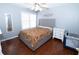 Bedroom has hardwood floors, window, ceiling fan, grey headboard and white dresser at 100 Cross Creek Dr, Lilburn, GA 30047