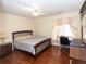 Comfortable bedroom featuring a ceiling fan, wood floors, and a large window with decoratice sheer curtains at 100 Cross Creek Dr, Lilburn, GA 30047