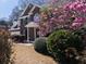 Charming two-story brick home with lush landscaping, including a beautiful magnolia tree in full bloom at 100 Cross Creek Dr, Lilburn, GA 30047