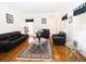 Elegant living room with hardwood floors, large windows, and comfortable black leather seating at 100 Cross Creek Dr, Lilburn, GA 30047