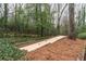 Bocce ball court in rear yard. Surrounded by mature trees, this outdoor space is perfect for entertaining at 3776 Powers Ferry Nw Rd, Atlanta, GA 30342