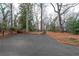 Long paved driveway leading up to a lovely two-story house surrounded by mature trees and landscaping at 3776 Powers Ferry Nw Rd, Atlanta, GA 30342