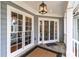Inviting front porch with a stylish lantern fixture and neutral-colored outdoor rug at 3776 Powers Ferry Nw Rd, Atlanta, GA 30342