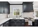 Well-lit modern kitchen with stainless steel appliances, white countertops, and dark cabinetry at 3776 Powers Ferry Nw Rd, Atlanta, GA 30342