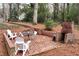 Brick patio features a brick fireplace, a seating area, and lush landscaping at 3776 Powers Ferry Nw Rd, Atlanta, GA 30342