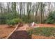 Backyard patio features brick fireplace, a seating area, and mature trees and landscaping at 3776 Powers Ferry Nw Rd, Atlanta, GA 30342