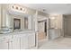 The bathroom features white cabinets, granite countertops, dual sinks and a view to main bedroom at 420 Hatcher Ct, Hampton, GA 30228