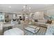 Open-concept living room with a view to a modern kitchen, stylish furniture, and lots of light at 420 Hatcher Ct, Hampton, GA 30228