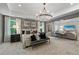 A spacious main bedroom features an elegant chandelier and sitting area for relaxing at 420 Hatcher Ct, Hampton, GA 30228