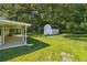 Expansive backyard featuring a storage shed, lush lawn, and mature trees at 1554 Pine Ct, Conley, GA 30288