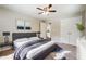 Bedroom featuring plush carpet, ceiling fan, and view into the attached bath at 1554 Pine Ct, Conley, GA 30288