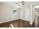 Bright bedroom showcasing a ceiling fan, hardwood floors, and natural light from the window at 1554 Pine Ct, Conley, GA 30288