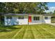 Charming single-story home with manicured lawn, white exterior, and bright orange front door at 1554 Pine Ct, Conley, GA 30288