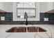 Close-up of kitchen sink with modern faucet, quartz countertop, and dark backsplash at 1554 Pine Ct, Conley, GA 30288