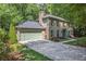 Brick home with attached garage and a long driveway, surrounded by mature trees, offering privacy at 2982 Huntshire Pl, Atlanta, GA 30340