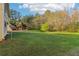 Expansive backyard with lush green grass, mature trees, and landscaping, perfect for outdoor activities at 4677 Creekside Cv, Atlanta, GA 30349