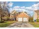 Inviting front exterior featuring a brick facade, two-car garage, and manicured lawn for a welcoming appeal at 4677 Creekside Cv, Atlanta, GA 30349