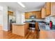 Well-lit kitchen features stainless steel appliances, wooden cabinets, and center island with stone countertop at 4677 Creekside Cv, Atlanta, GA 30349