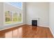 Bright living room featuring a fireplace, hardwood floors, and large, light-filled windows at 4677 Creekside Cv, Atlanta, GA 30349