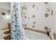 Bathtub with shower featuring tile walls with palm tree decoration and light blue shower curtain at 1532 Wethersfield Rd, Snellville, GA 30078
