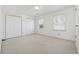 Bright bedroom featuring neutral carpet, two windows, and two closets at 1532 Wethersfield Rd, Snellville, GA 30078