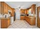 Well-lit kitchen with wood cabinets, granite countertops, stainless steel refrigerator, and tile floors at 1532 Wethersfield Rd, Snellville, GA 30078