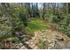 Lush backyard with stone fire pit, natural landscaping, and space for outdoor activities at 185 E Wesley Ne Rd, Atlanta, GA 30305