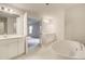 Bright primary bathroom with double vanities, stand-alone tub, and tile floor at 428 Hatcher Ct, Hampton, GA 30228