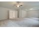 Spacious primary bedroom with tray ceiling, ceiling fan and neutral carpeting at 428 Hatcher Ct, Hampton, GA 30228
