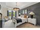 Cozy bedroom with a decorative gray accent wall, neutral-toned bedding, and ample natural light at 141 Compass Rd, Hampton, GA 30228