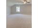 Large bonus room featuring plush carpeting, neutral paint, a ceiling fan, and a large window at 141 Compass Rd, Hampton, GA 30228