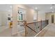 Upstairs hallway featuring iron railings and views into adjacent rooms, creating an open and airy feel at 141 Compass Rd, Hampton, GA 30228